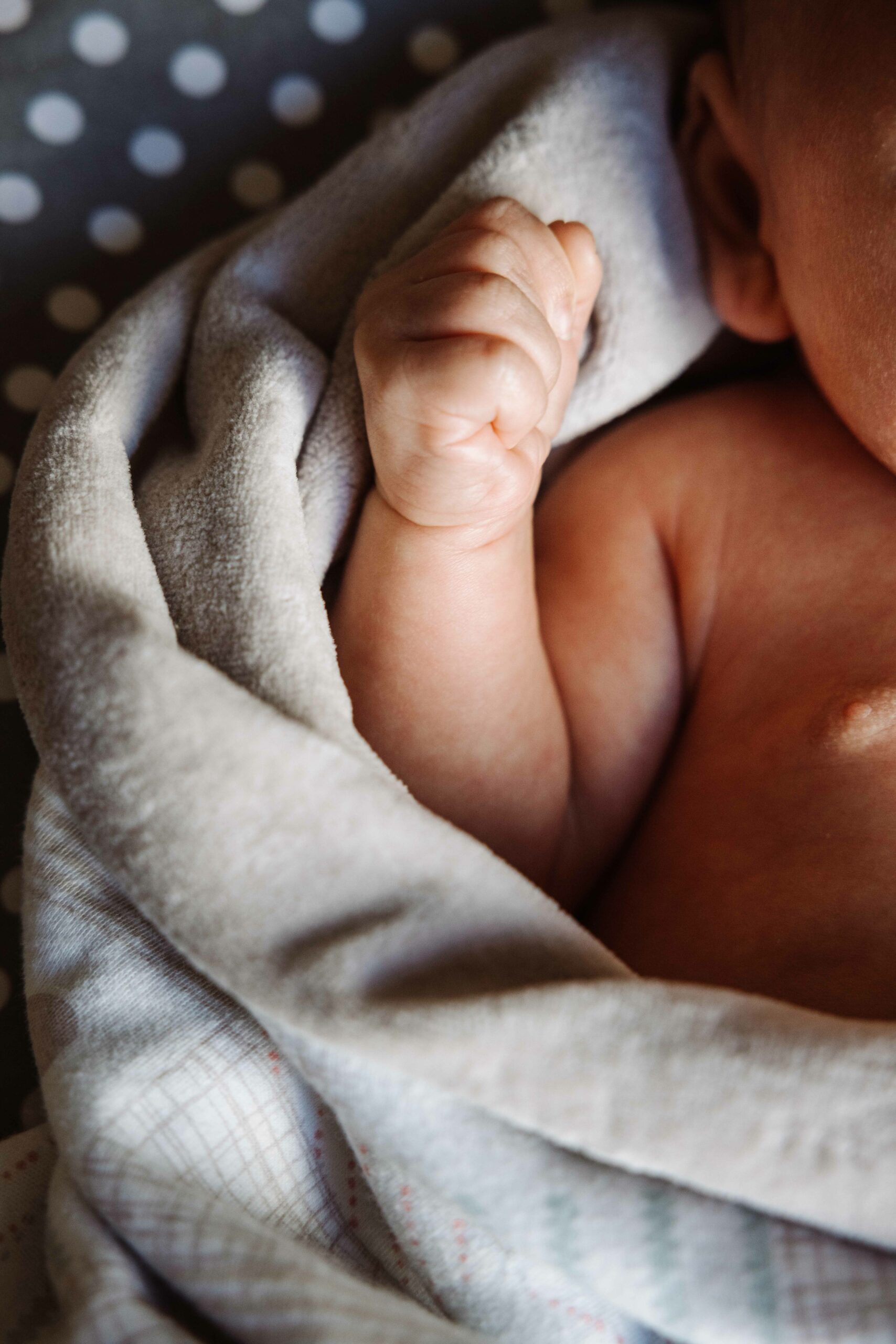 Hand und Oberkörper neugeborenes Baby